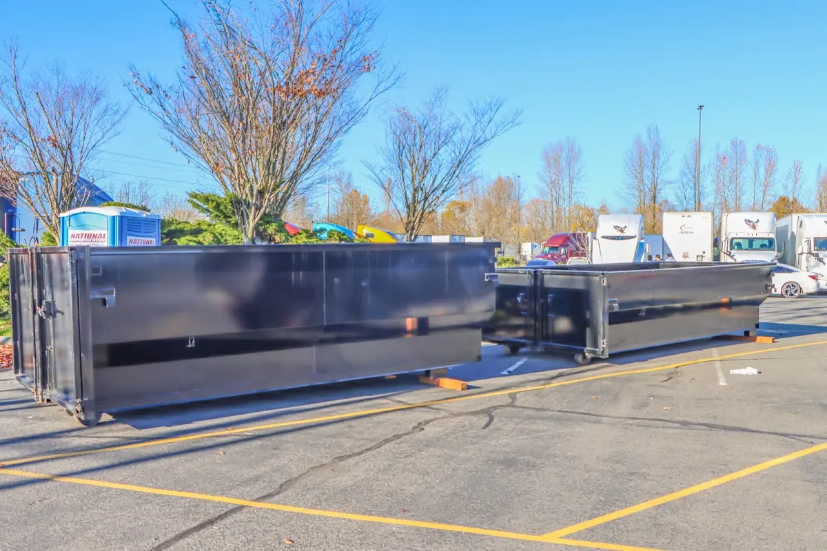 Professional dumpster rental service with roll-off container on residential driveway in New Castle